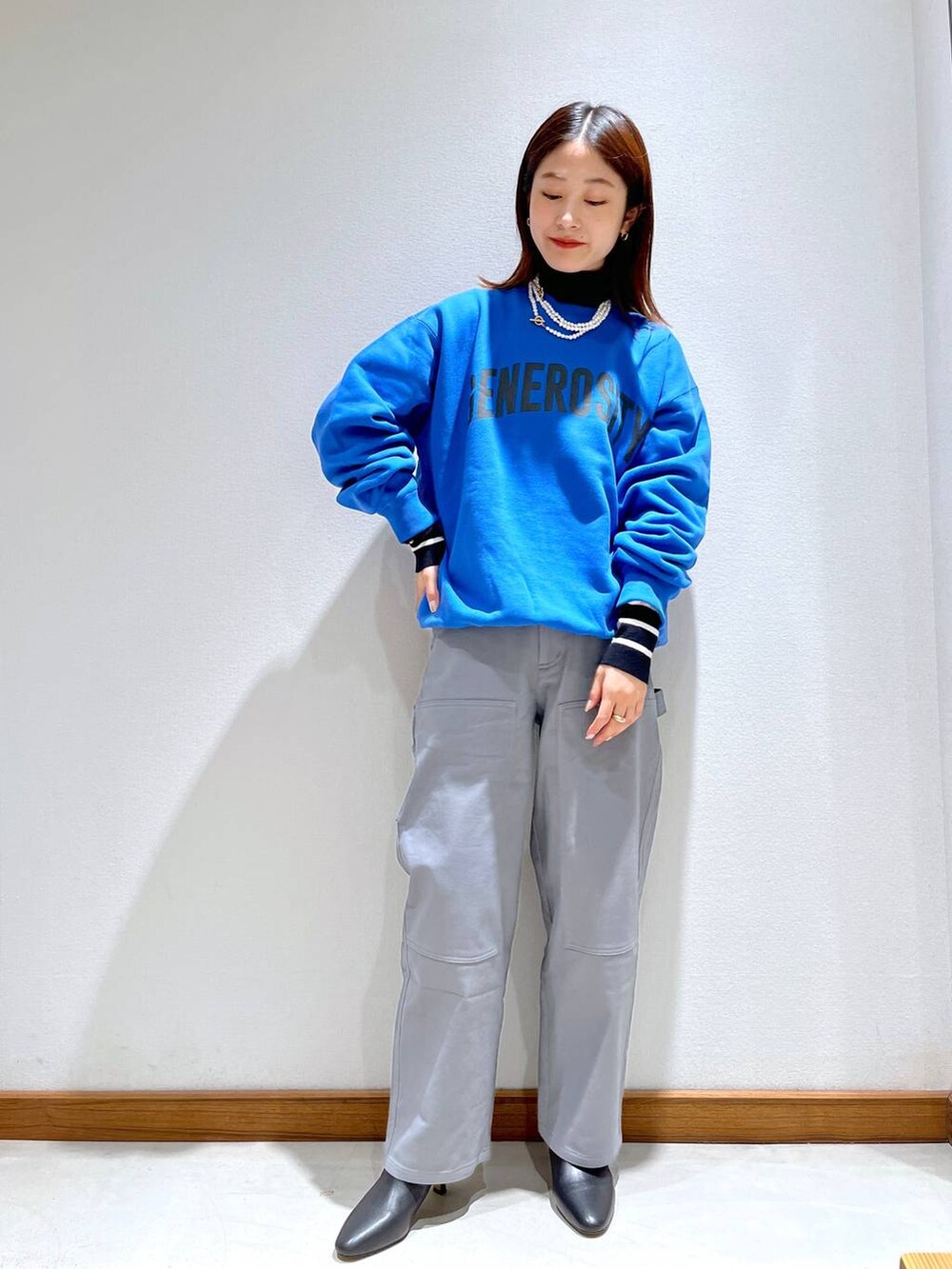 ブラック系のニット/セーター、ブラック系のブーツ、グレー系のノーカラージャケットを着用したレディースの秋コーディネートの5枚目の写真