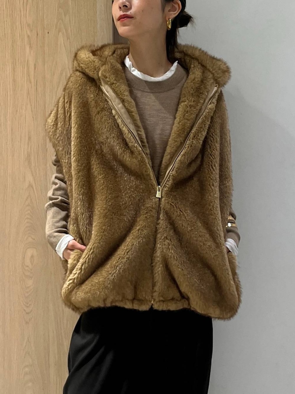 ホワイト系のTシャツ/カットソー、ベージュ系のベスト、ブラウン系のニット/セーターを着用したレディースの秋コーディネートの6枚目の写真