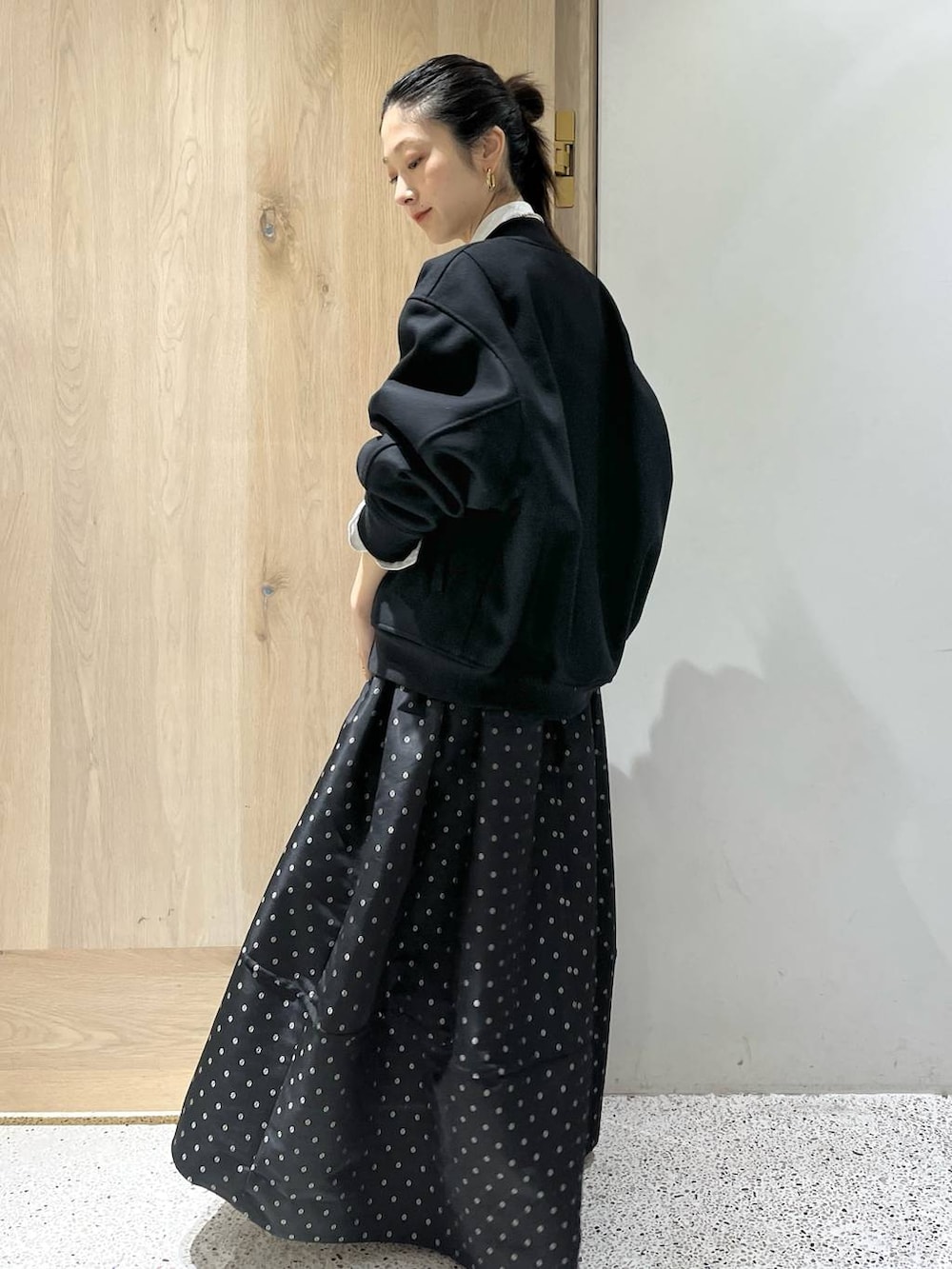 ブラック系のスカート、ブラック系のブルゾン、ホワイト系のシャツ/ブラウスを着用したレディースの秋コーディネートの6枚目の写真