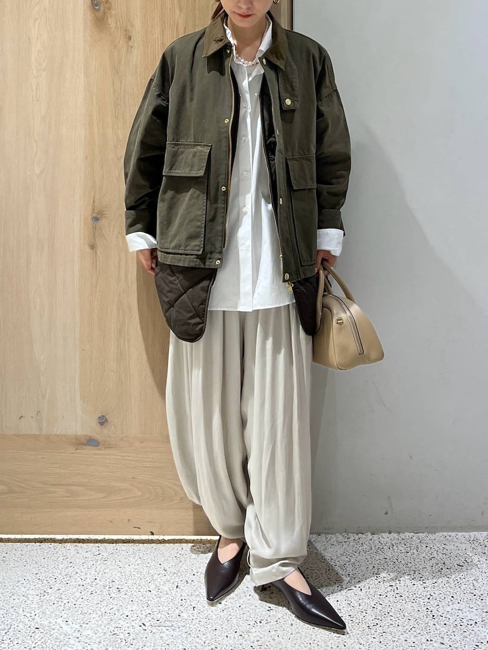 ホワイト系のシャツ/ブラウス、グリーン系のブルゾン、ホワイト系のその他パンツを着用したレディースの秋コーディネートの5枚目の写真