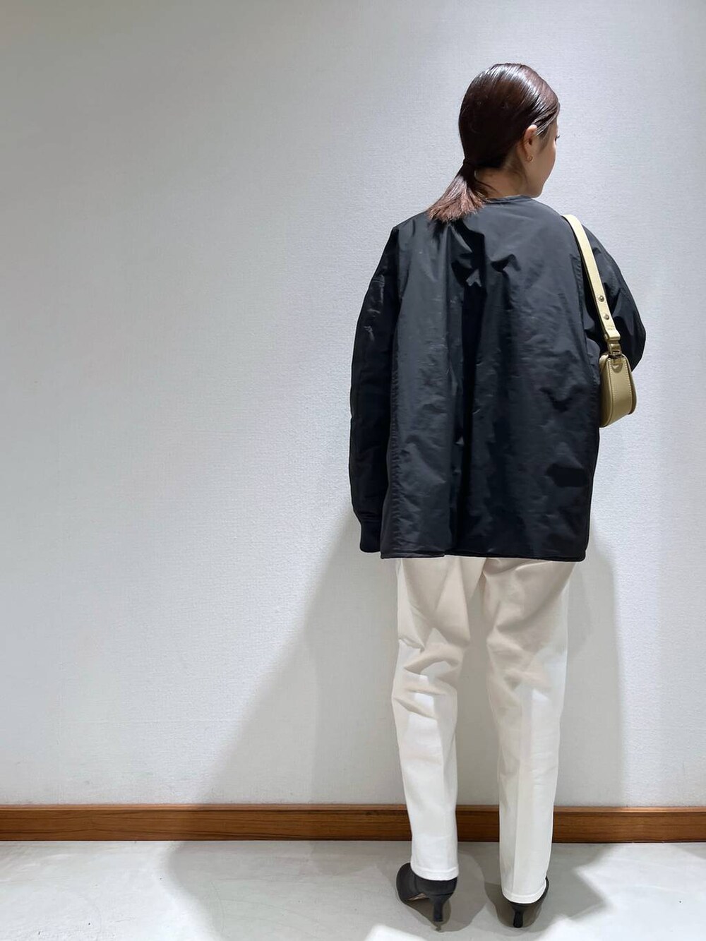 ブラック系のブーツ、ベージュ系のショルダーバッグ、ホワイト系のニット/セーターを着用したレディースの冬コーディネートの4枚目の写真