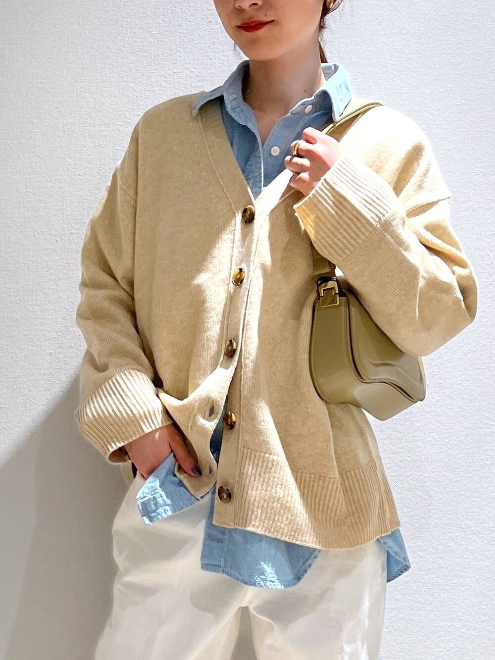 ブラック系のパンプス、ベージュ系のショルダーバッグ、ベージュ系のカーディガン/ボレロを着用したレディースの冬コーディネートの5枚目の写真