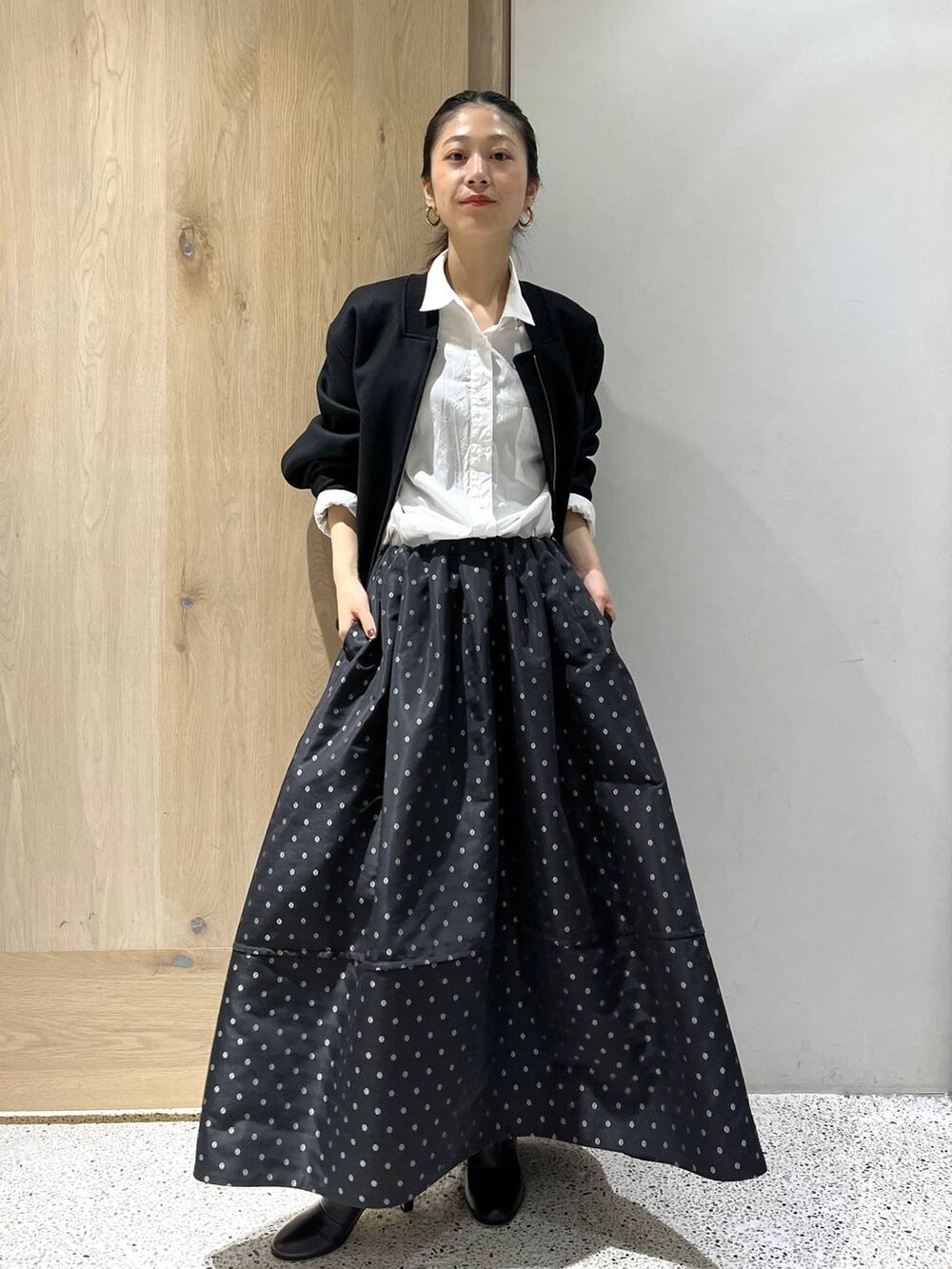 ブラック系のスカート、ブラック系のブルゾン、ホワイト系のシャツ/ブラウスを着用したレディースの秋コーディネートの8枚目の写真