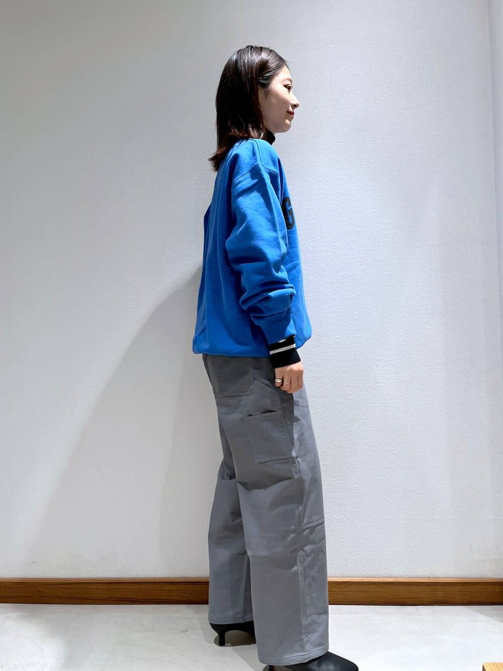 ブラック系のニット/セーター、ブラック系のブーツ、グレー系のノーカラージャケットを着用したレディースの秋コーディネートの6枚目の写真