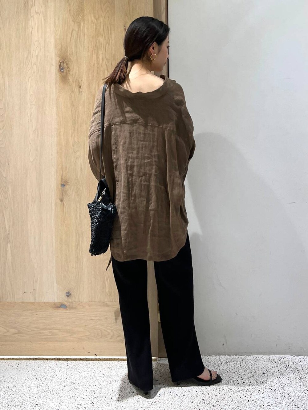 ブラック系のその他パンツ、ブラウン系のシャツ/ブラウス、ゴールド系のバングル/リストバンドを着用したレディースの春コーディネートの4枚目の写真