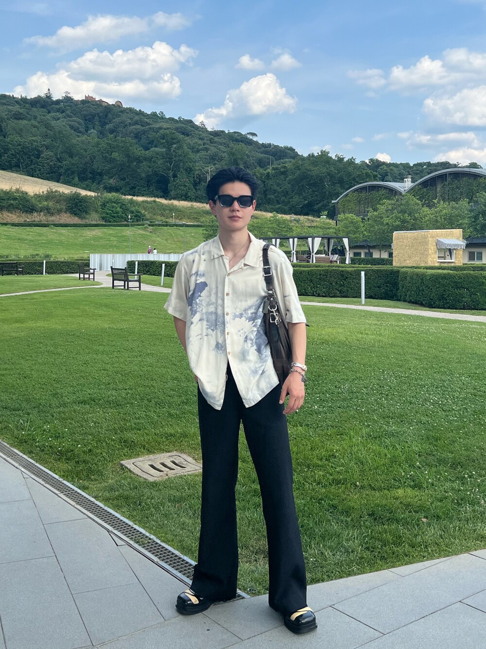 ブラック系のドレスシューズ、ブラウン系のキーホルダー、ブラック系のネックレスを着用したメンズの夏コーディネートの4枚目の写真