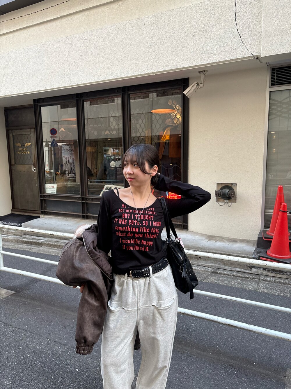 ブラック系のTシャツ/カットソー、グレー系のスウェットパンツ、ブラック系のショルダーバッグを着用したレディースの冬コーディネートの2枚目の写真
