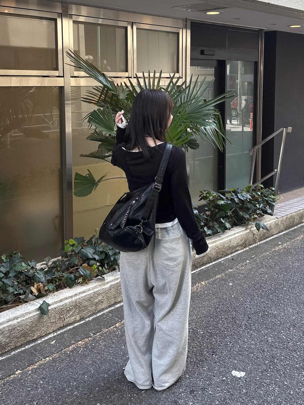 ブラック系のTシャツ/カットソー、グレー系のスウェットパンツ、ブラック系のパンプスを着用したレディースの冬コーディネートの2枚目の写真