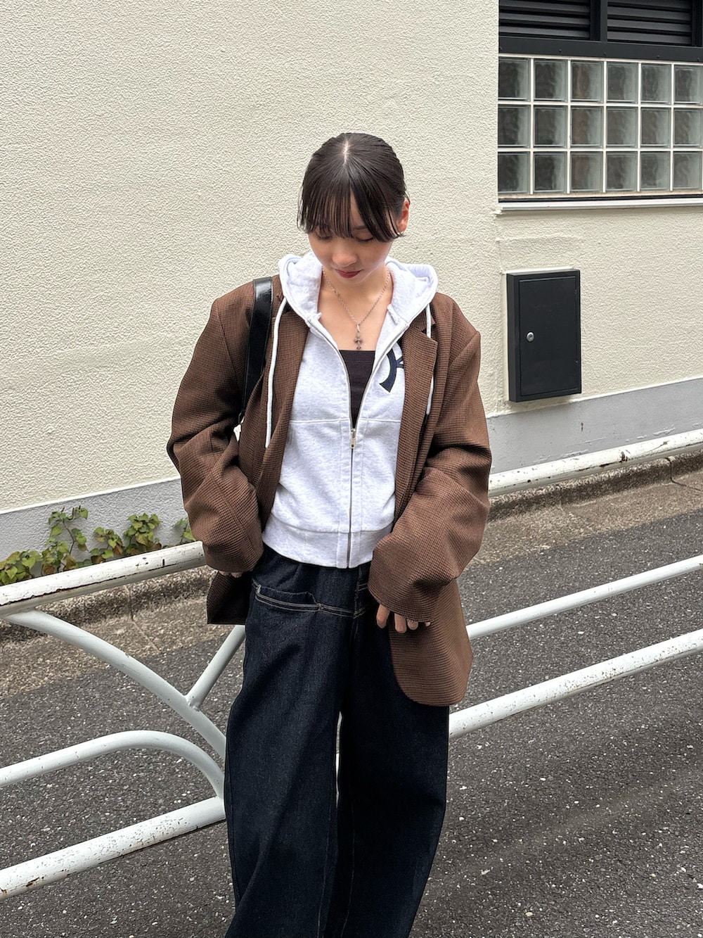 ブラック系のパンプス、グレー系のパーカー、ブラウン系のテーラードジャケットを着用したレディースの秋コーディネートの2枚目の写真