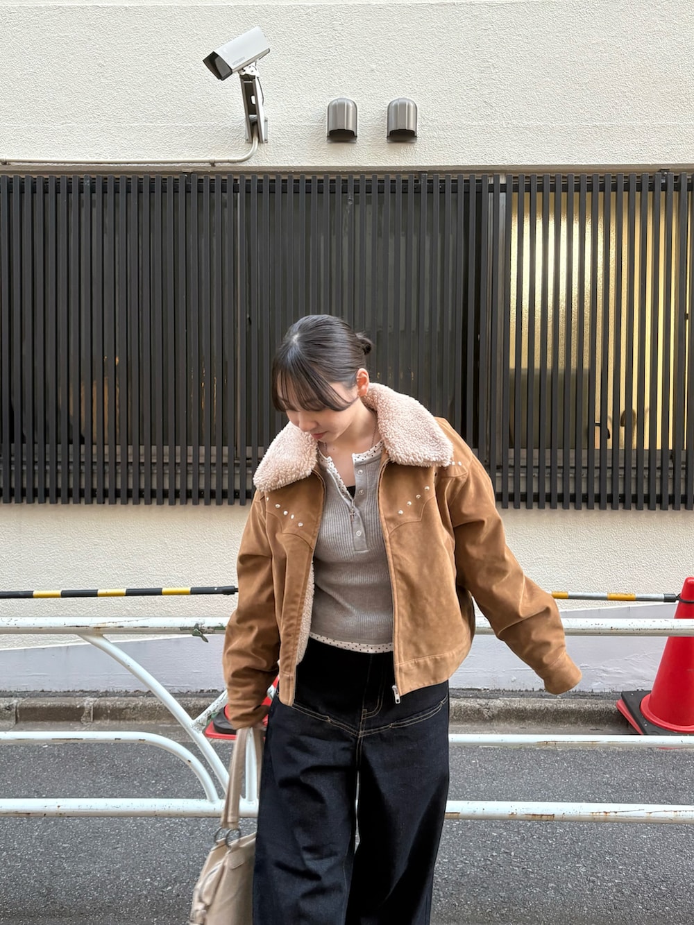 グレー系のニット/セーター、イエロー系のブルゾン、ブルー系のデニムパンツを着用したレディースの秋コーディネートの2枚目の写真