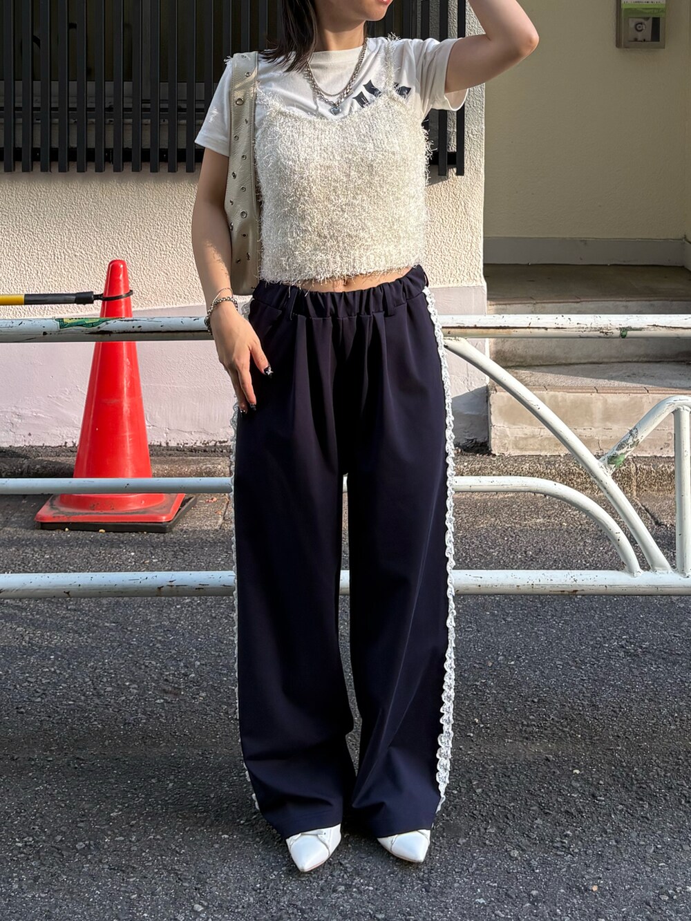 ホワイト系のニット/セーター、ホワイト系のTシャツ/カットソー、ホワイト系のショルダーバッグを着用したレディースの秋コーディネートの3枚目の写真