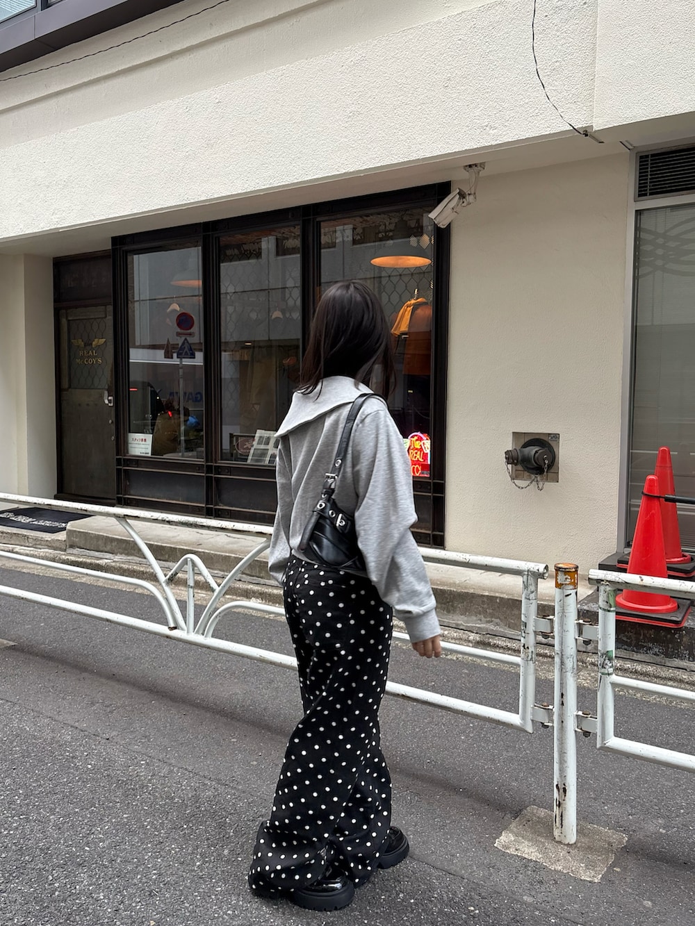 グレー系のパーカー、ホワイト系のキャミソール、ブラック系のその他パンツを着用したレディースの春コーディネートの2枚目の写真