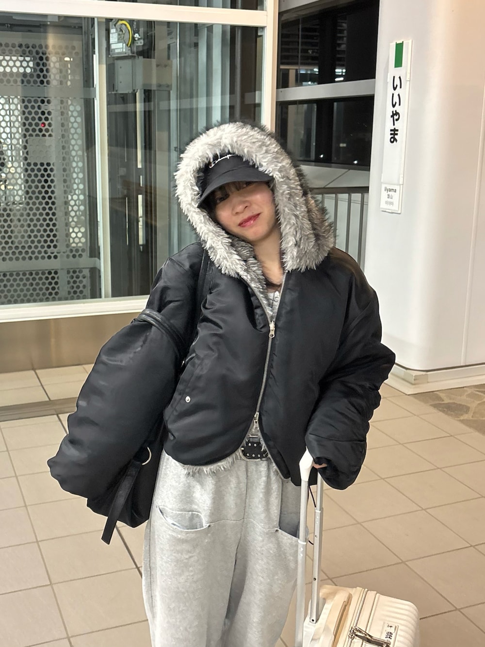 ブラック系のブルゾン、グレー系のスウェットパンツ、ブラック系のボストンバッグを着用したレディースの冬コーディネートの3枚目の写真