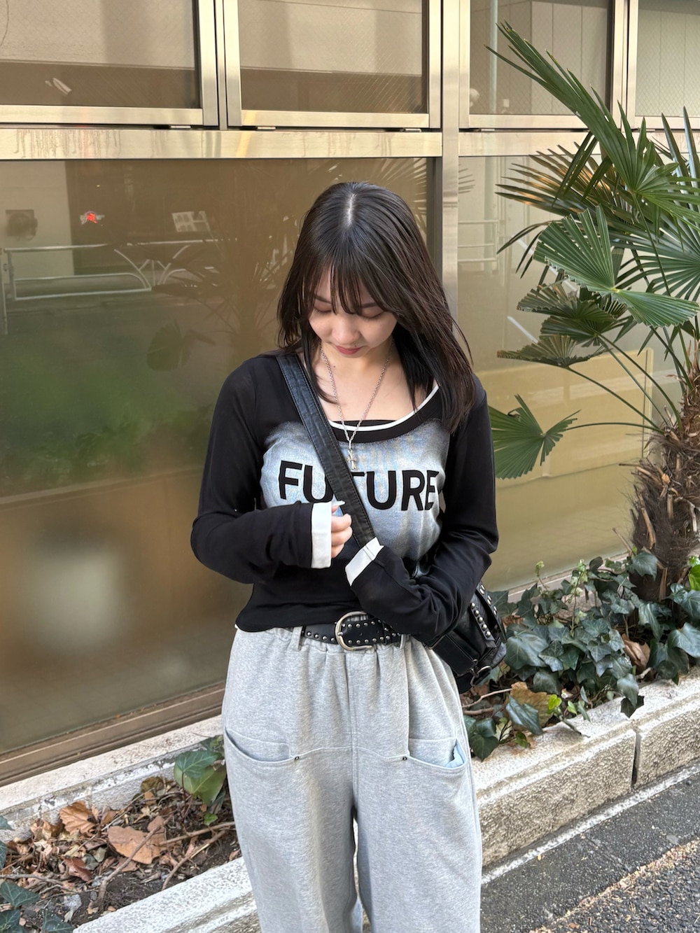 ブラック系のTシャツ/カットソー、グレー系のスウェットパンツ、ブラック系のパンプスを着用したレディースの冬コーディネートの3枚目の写真