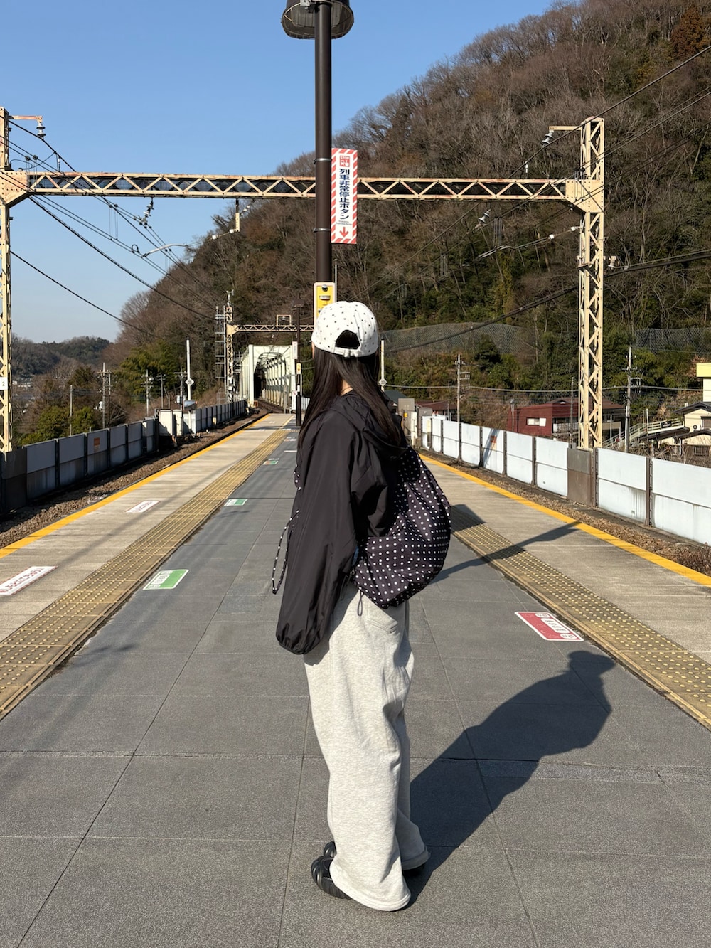 グレー系のスウェットパンツ、ブラック系のジャケット/アウター、ホワイト系のスニーカーを着用したレディースの春コーディネートの2枚目の写真
