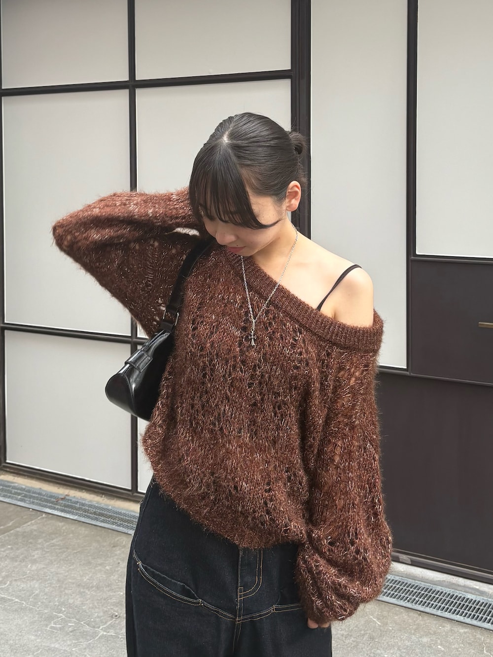 ブラウン系のニット/セーター、ブルー系のデニムパンツ、ブラック系のパンプスを着用したレディースの秋コーディネートの2枚目の写真