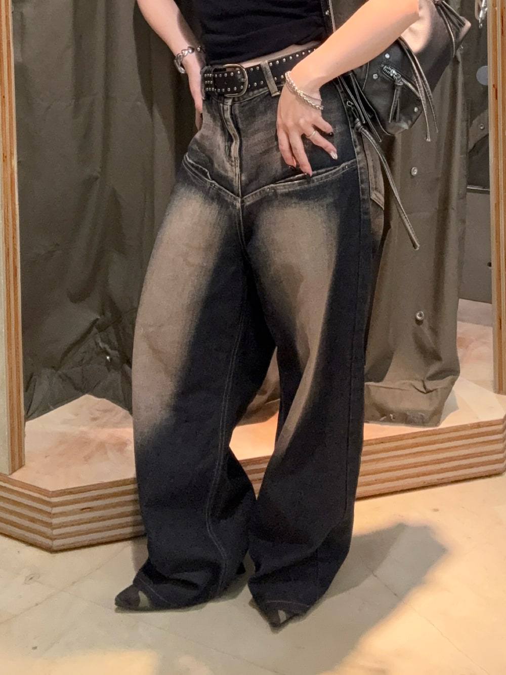 ブラック系のタンクトップ、ブルー系のデニムパンツ、グリーン系のパンプスを着用したレディースの夏コーディネートの2枚目の写真