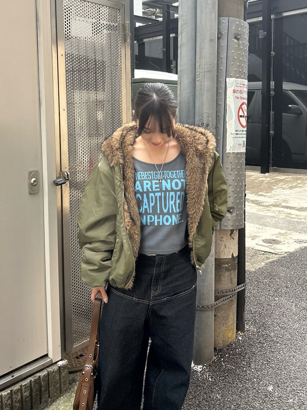 グレー系のニット/セーター、ブルー系のデニムパンツ、グリーン系のブルゾンを着用したレディースの秋コーディネートの2枚目の写真