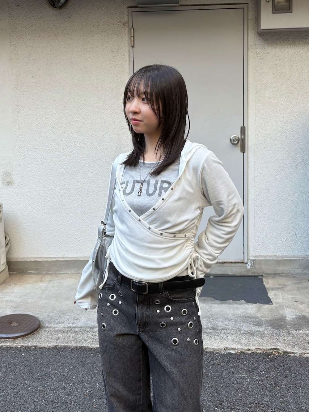 ブラック系のデニムパンツ、グレー系のTシャツ/カットソー、ホワイト系のパーカーを着用したレディースの冬コーディネートの2枚目の写真