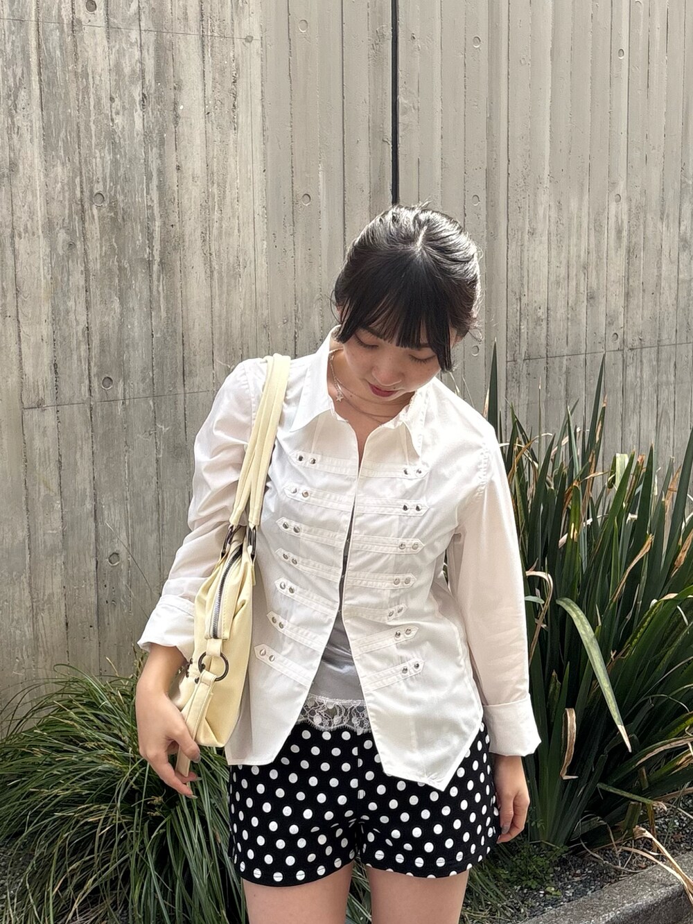 ブラック系のその他パンツ、ホワイト系のシャツ/ブラウス、イエロー系のショルダーバッグを着用したレディースの春コーディネートの2枚目の写真