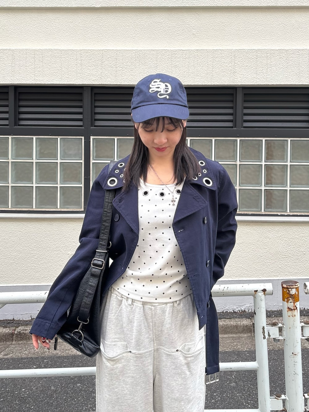 ブラック系のショルダーバッグ、グレー系のスウェットパンツ、ブルー系のピーコートを着用したレディースの冬コーディネートの2枚目の写真