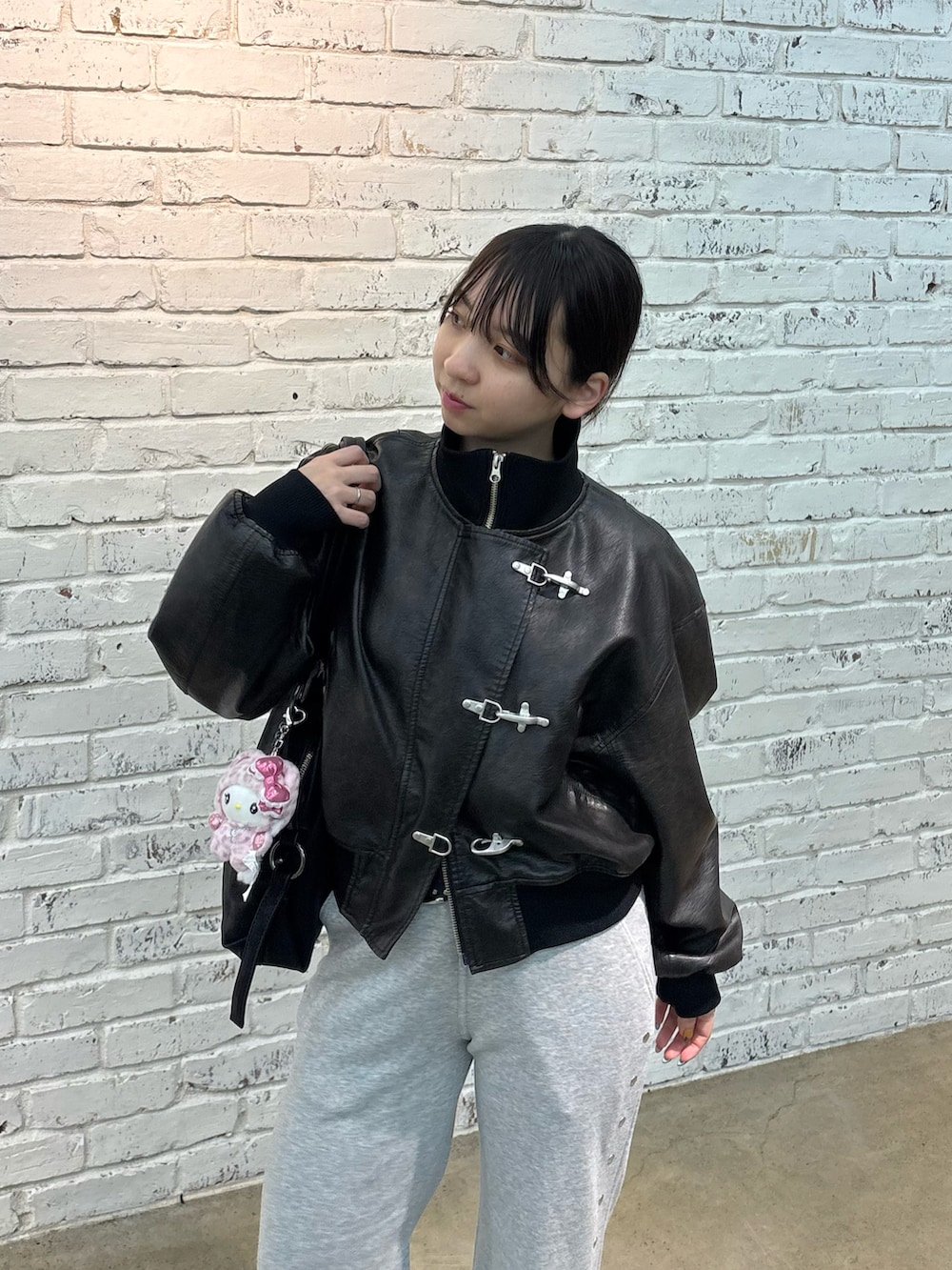 ブラック系のブルゾン、ブラック系のパンプス、ブラック系のショルダーバッグを着用したレディースの冬コーディネートの2枚目の写真