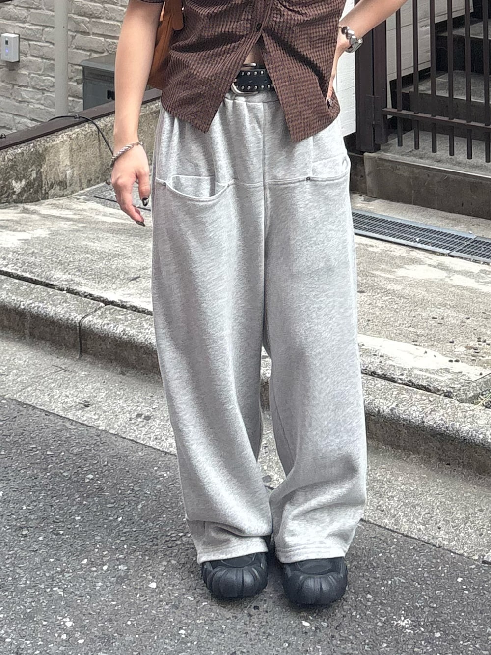 ブラウン系のシャツ/ブラウス、グレー系のスウェットパンツ、ブラック系のベルトを着用したレディースの夏コーディネートの3枚目の写真