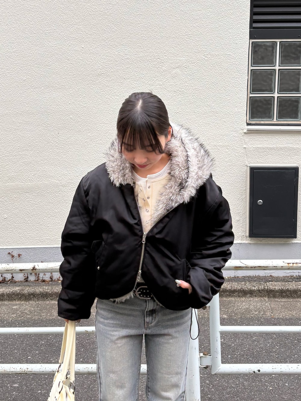 ブラック系のブルゾン、グレー系のデニムパンツ、ブラック系のパンプスを着用したレディースの冬コーディネートの3枚目の写真