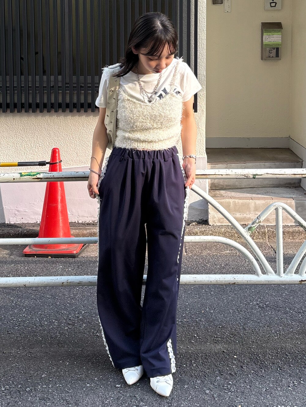 ホワイト系のニット/セーター、ホワイト系のTシャツ/カットソー、ホワイト系のショルダーバッグを着用したレディースの秋コーディネートの2枚目の写真