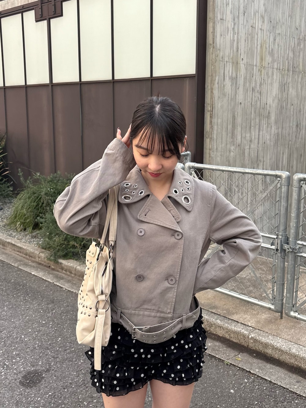 ブラック系のその他パンツ、グレー系のピーコート、イエロー系のショルダーバッグを着用したレディースの春コーディネートの2枚目の写真