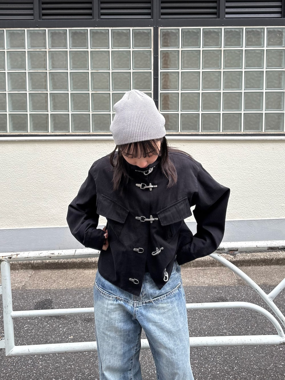 ブラック系のミリタリージャケット、ブルー系のデニムパンツを着用したレディースの春コーディネートの2枚目の写真