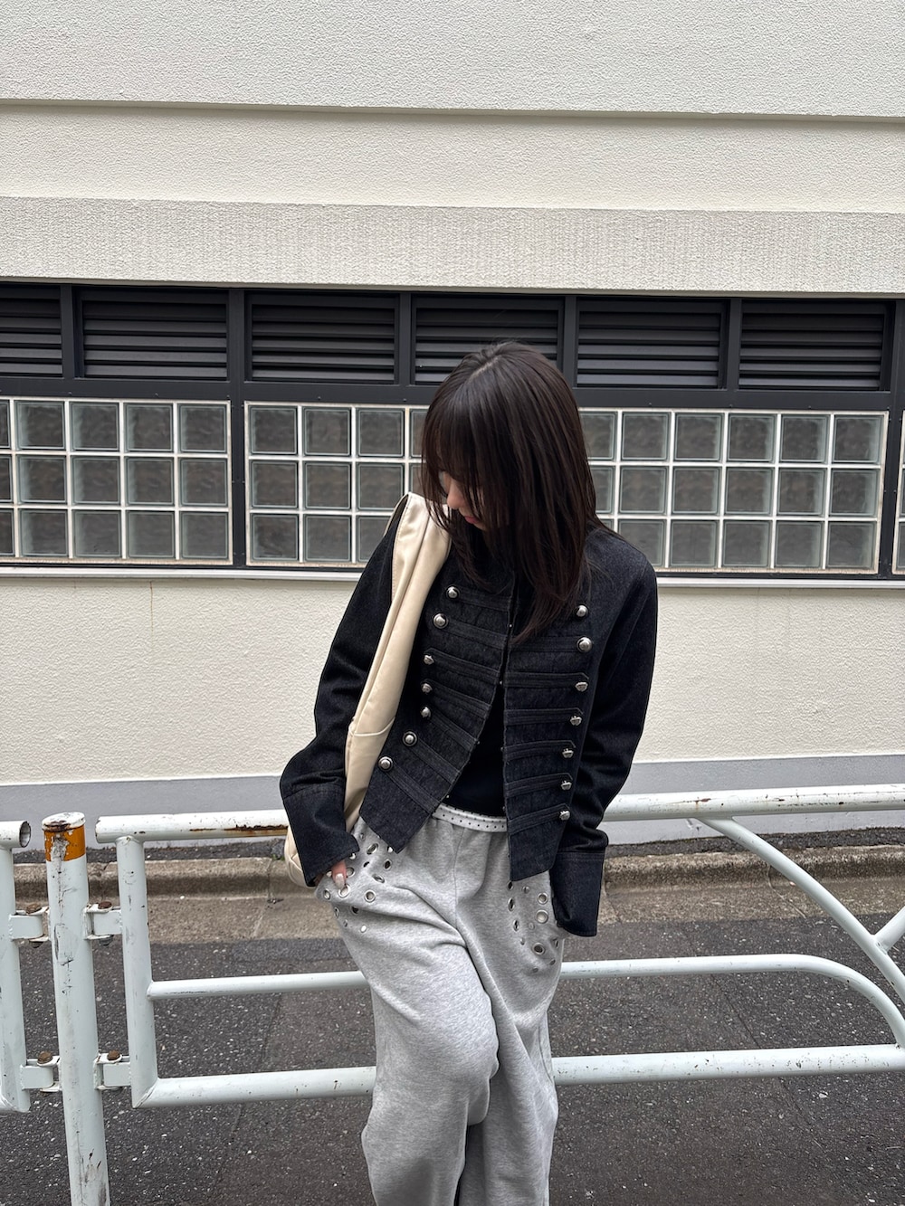 ブラック系のデニムジャケット、ブラック系のTシャツ/カットソー、グレー系のスウェットパンツを着用したレディースの春コーディネートの3枚目の写真