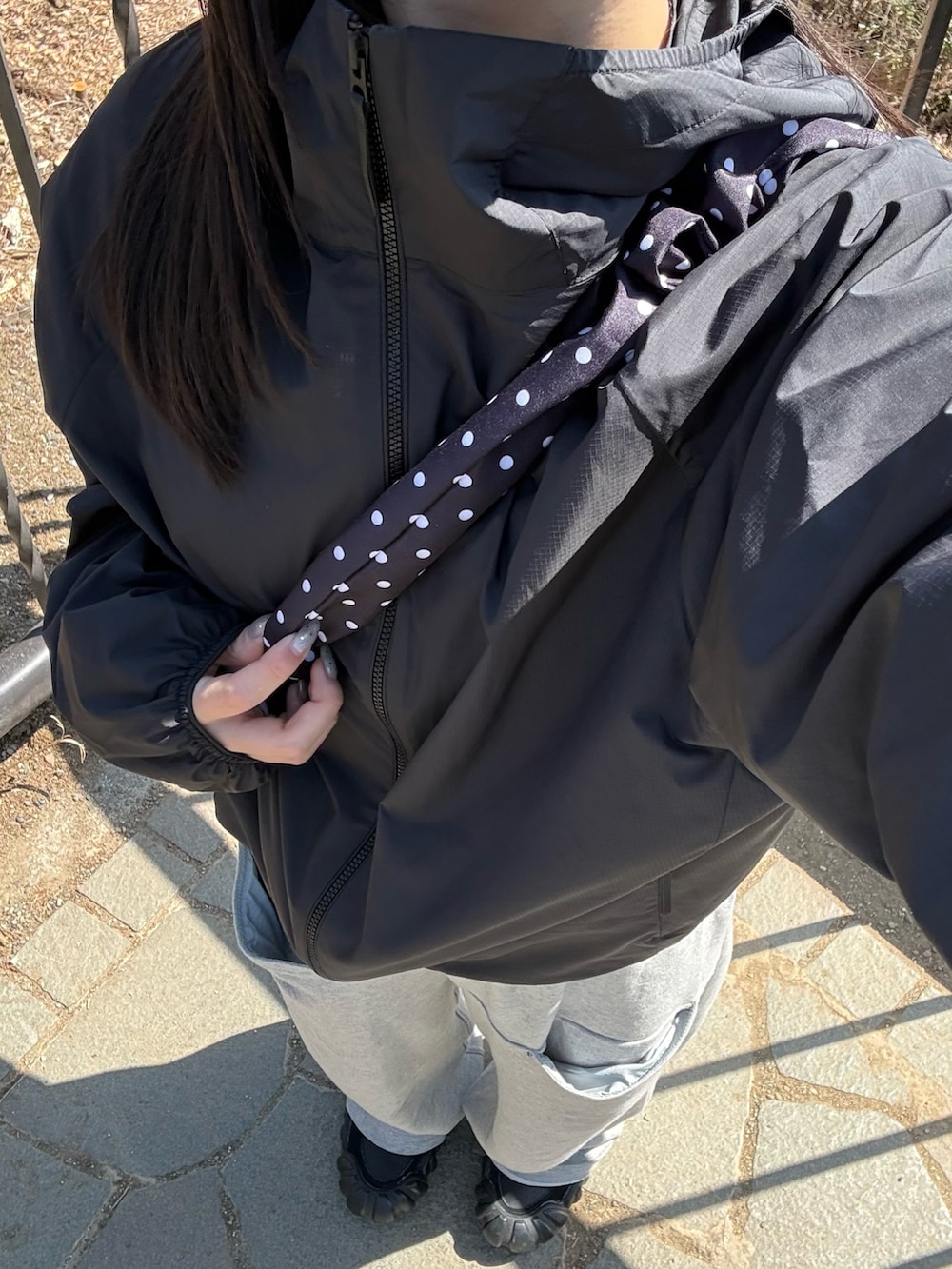 グレー系のスウェットパンツ、ブラック系のジャケット/アウター、ホワイト系のスニーカーを着用したレディースの春コーディネートの4枚目の写真