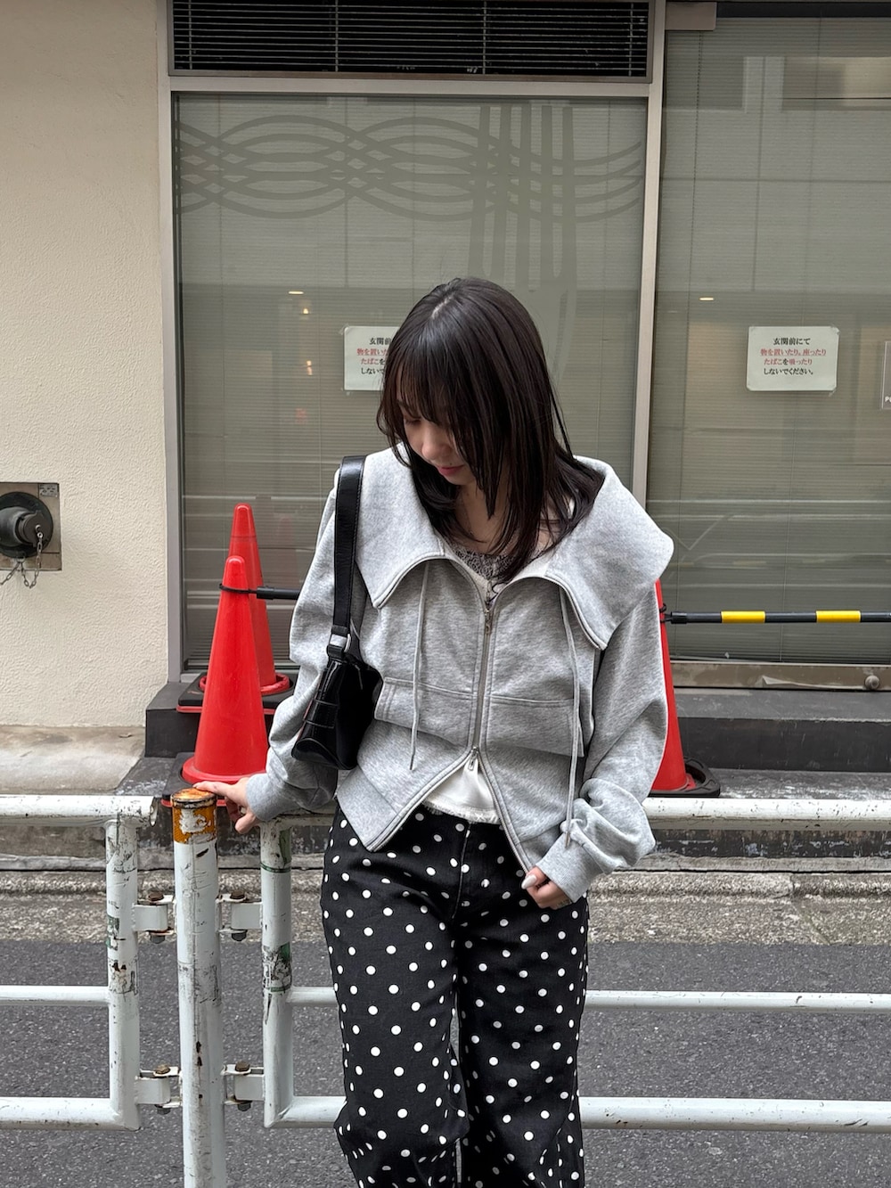 グレー系のパーカー、ホワイト系のキャミソール、ブラック系のその他パンツを着用したレディースの春コーディネートの3枚目の写真