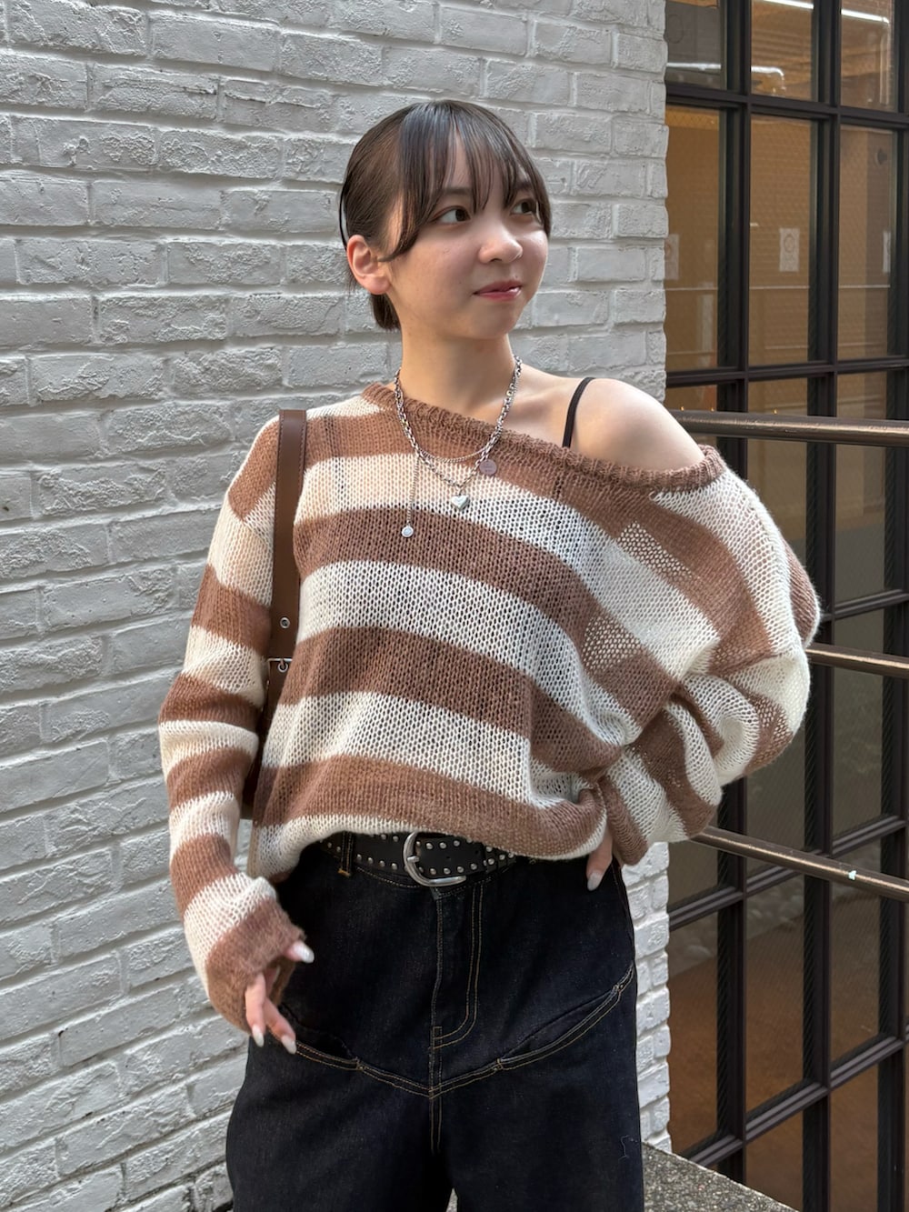 ホワイト系のニット/セーター、ブルー系のデニムパンツ、ブラック系のパンプスを着用したレディースの秋コーディネートの2枚目の写真