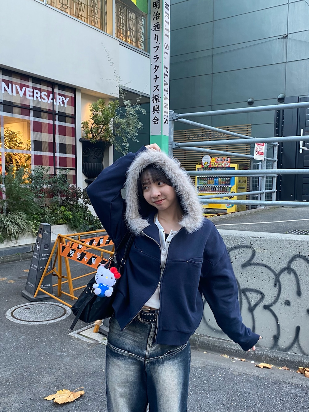 ブルー系のデニムパンツ、ブルー系のパーカー、ブラック系のショルダーバッグを着用したレディースの秋コーディネートの2枚目の写真