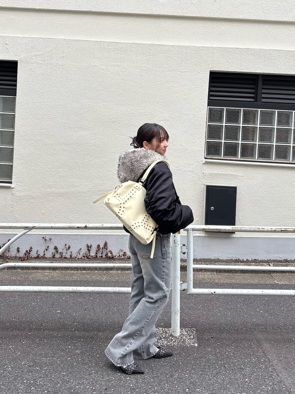 ブラック系のブルゾン、グレー系のデニムパンツ、ブラック系のパンプスを着用したレディースの冬コーディネートの2枚目の写真