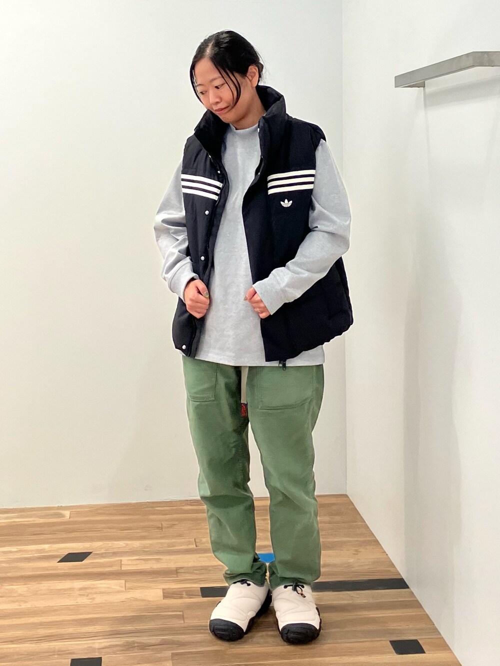 グレー系のTシャツ/カットソー、ブラック系のダウンベスト、ベージュ系のシューズを着用したレディースの秋コーディネートの2枚目の写真