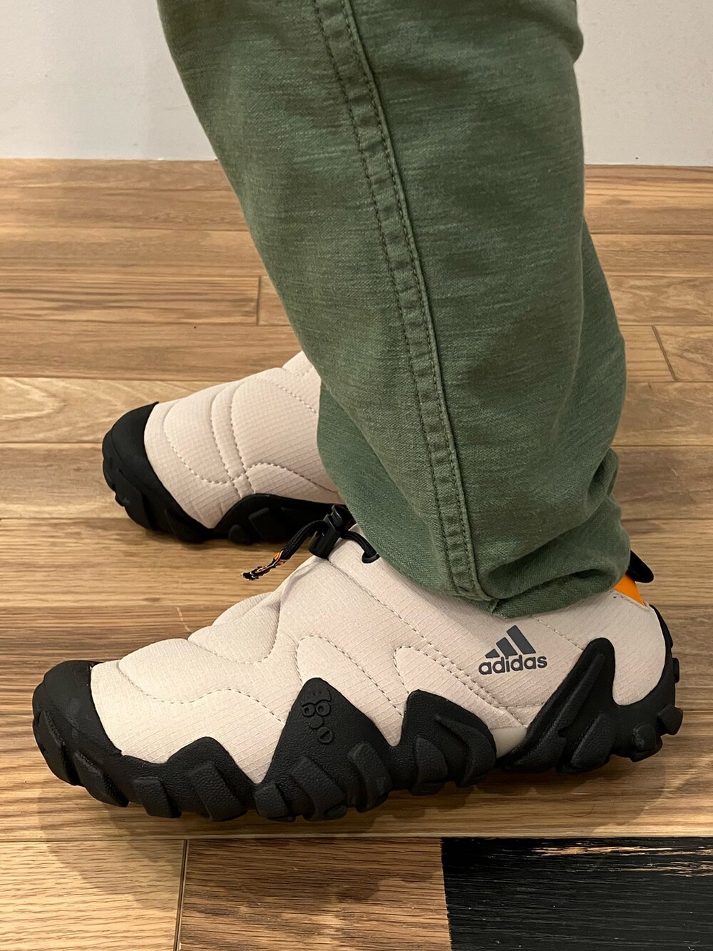 グレー系のTシャツ/カットソー、ブラック系のダウンベスト、ベージュ系のシューズを着用したレディースの秋コーディネートの4枚目の写真