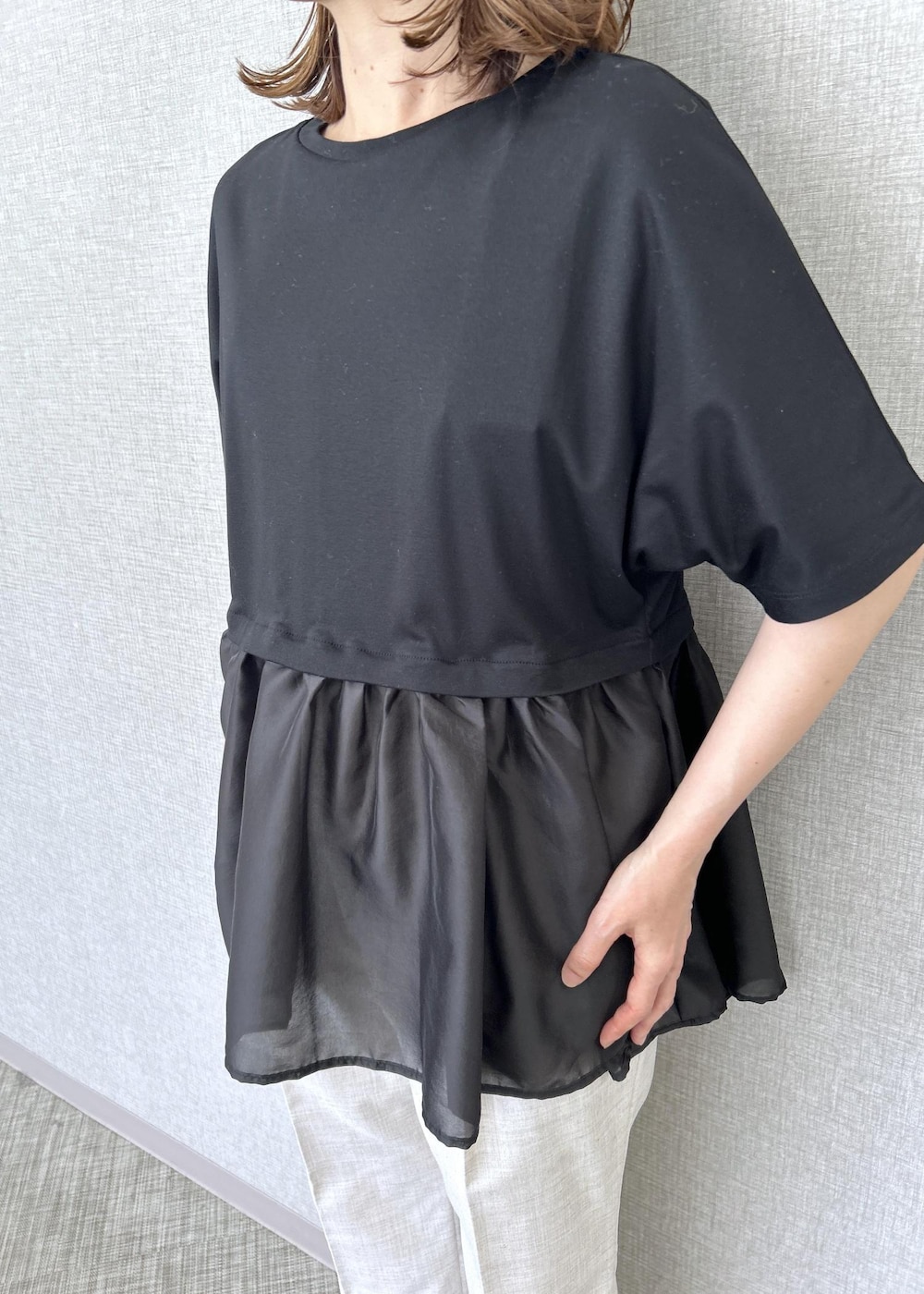 ホワイト系のハンドバッグ、ベージュ系のその他パンツ、ブラック系のTシャツ/カットソーを着用したレディースの夏コーディネートの6枚目の写真