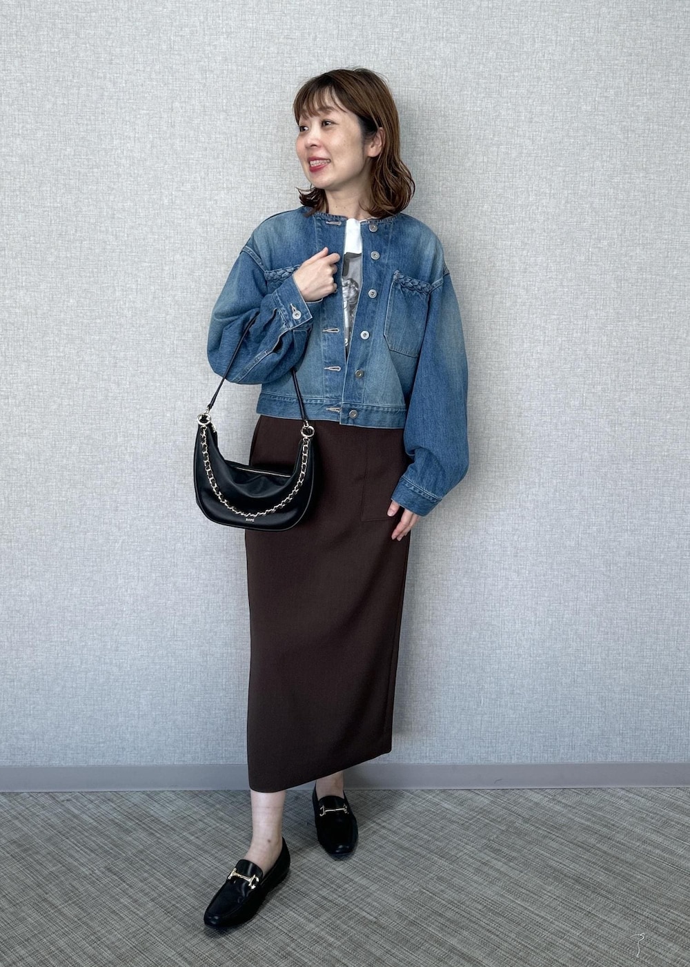 ホワイト系のTシャツ/カットソー、ブラック系のショルダーバッグ、ブルー系のデニムジャケットを着用したレディースの春コーディネートの2枚目の写真