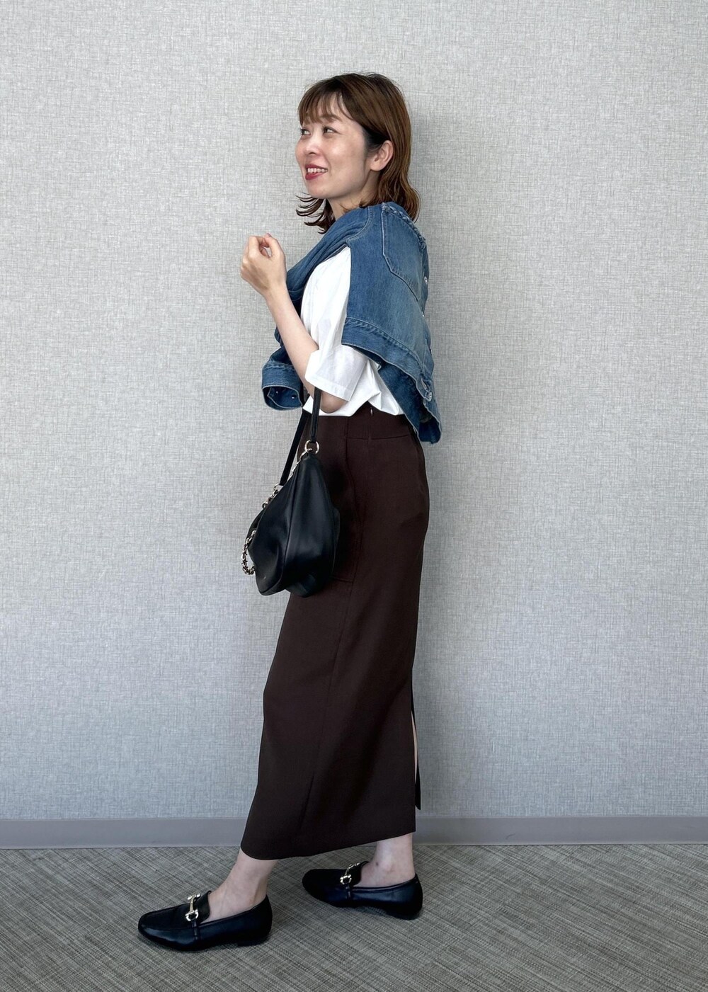 ホワイト系のTシャツ/カットソー、ブラック系のショルダーバッグ、ブルー系のデニムジャケットを着用したレディースの春コーディネートの4枚目の写真