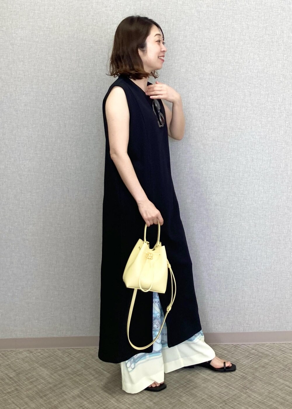 ベージュ系のハンドバッグ、ホワイト系のその他パンツ、ブラック系のサンダルを着用したレディースの春コーディネートの3枚目の写真