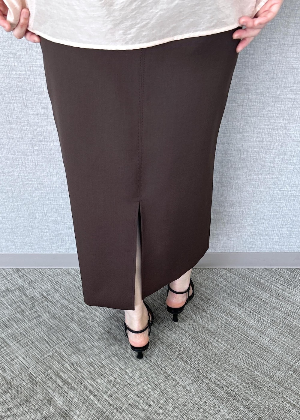 ブラック系のパンプス、ベージュ系のハンドバッグ、ブラウン系のスカートを着用したレディースの冬コーディネートの9枚目の写真