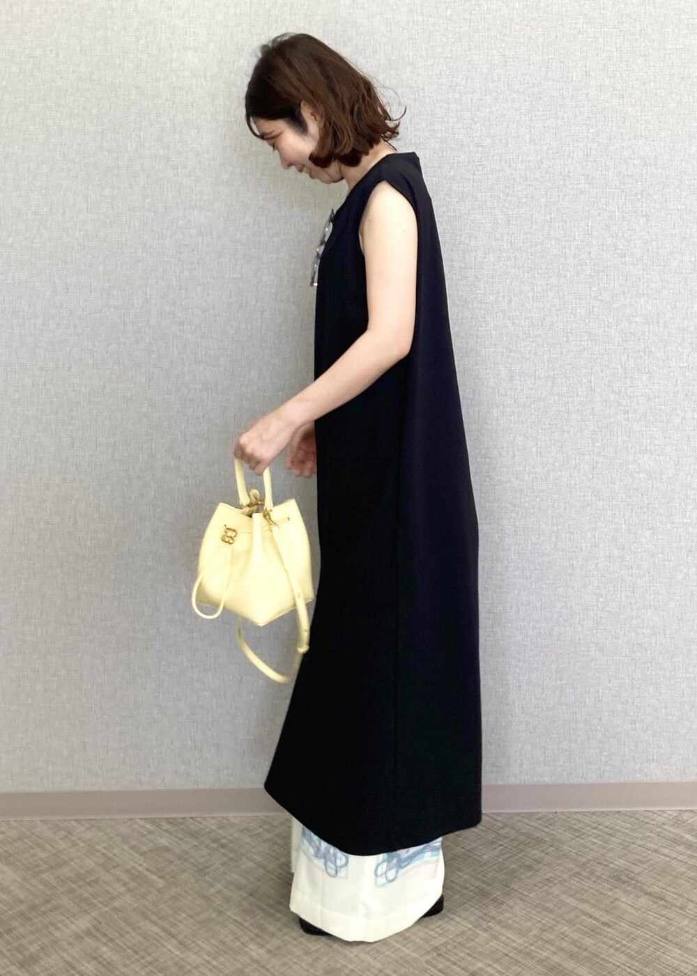 ベージュ系のハンドバッグ、ホワイト系のその他パンツ、ブラック系のサンダルを着用したレディースの春コーディネートの2枚目の写真