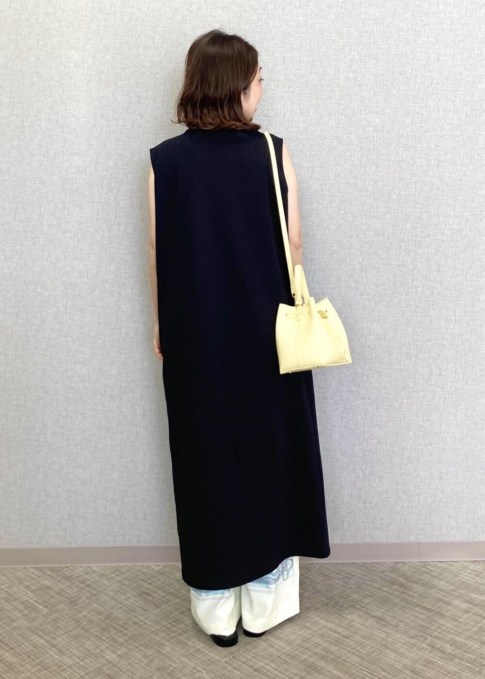 ベージュ系のハンドバッグ、ホワイト系のその他パンツ、ブラック系のサンダルを着用したレディースの春コーディネートの4枚目の写真