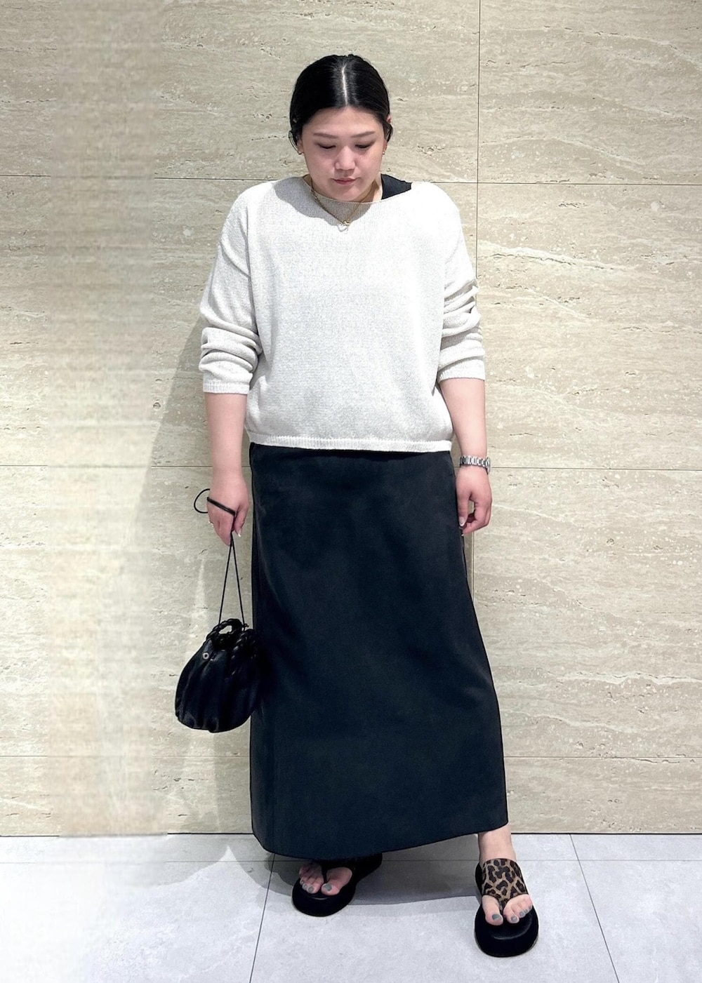 ホワイト系のニット/セーター、ブラック系のワンピースを着用したレディースの春コーディネートの2枚目の写真