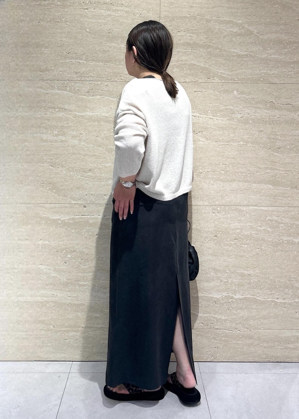 ホワイト系のニット/セーター、ブラック系のワンピースを着用したレディースの春コーディネートの4枚目の写真