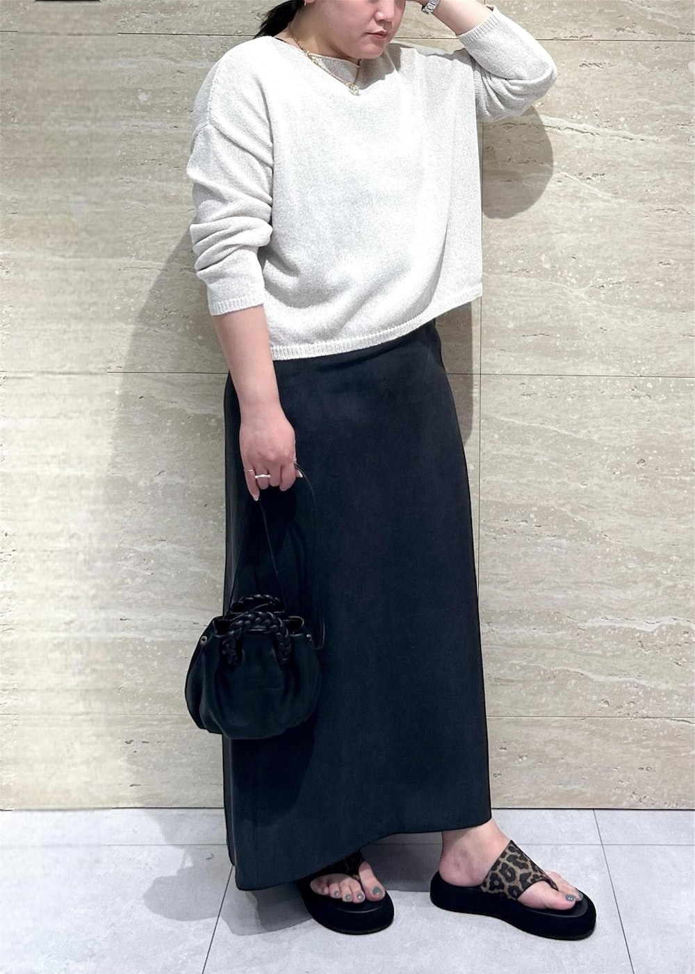 ホワイト系のニット/セーター、ブラック系のワンピースを着用したレディースの春コーディネートの3枚目の写真