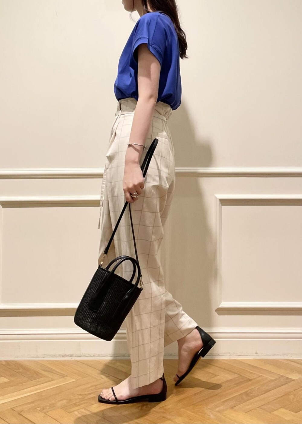 ブラック系のサンダル、ブラック系のハンドバッグ、ブルー系のTシャツ/カットソーを着用したレディースの夏コーディネートの2枚目の写真